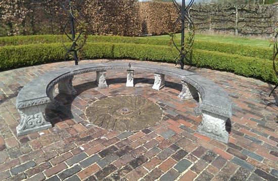 A large composition stone horseshoe garden bench approximately 11ft max diameter.